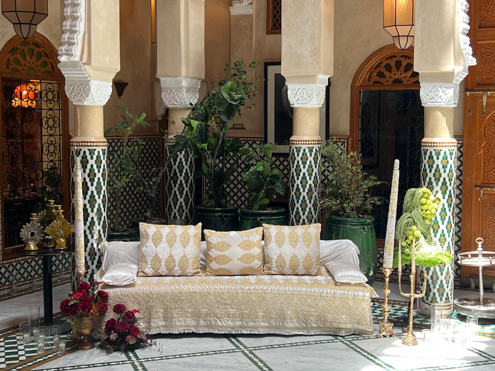 Wedding at Dar Dada Casablanca — gilded welcome mirror, crimson and burgundy floral centerpieces, zellige tables and candlelight, produced by SBAI Events Production