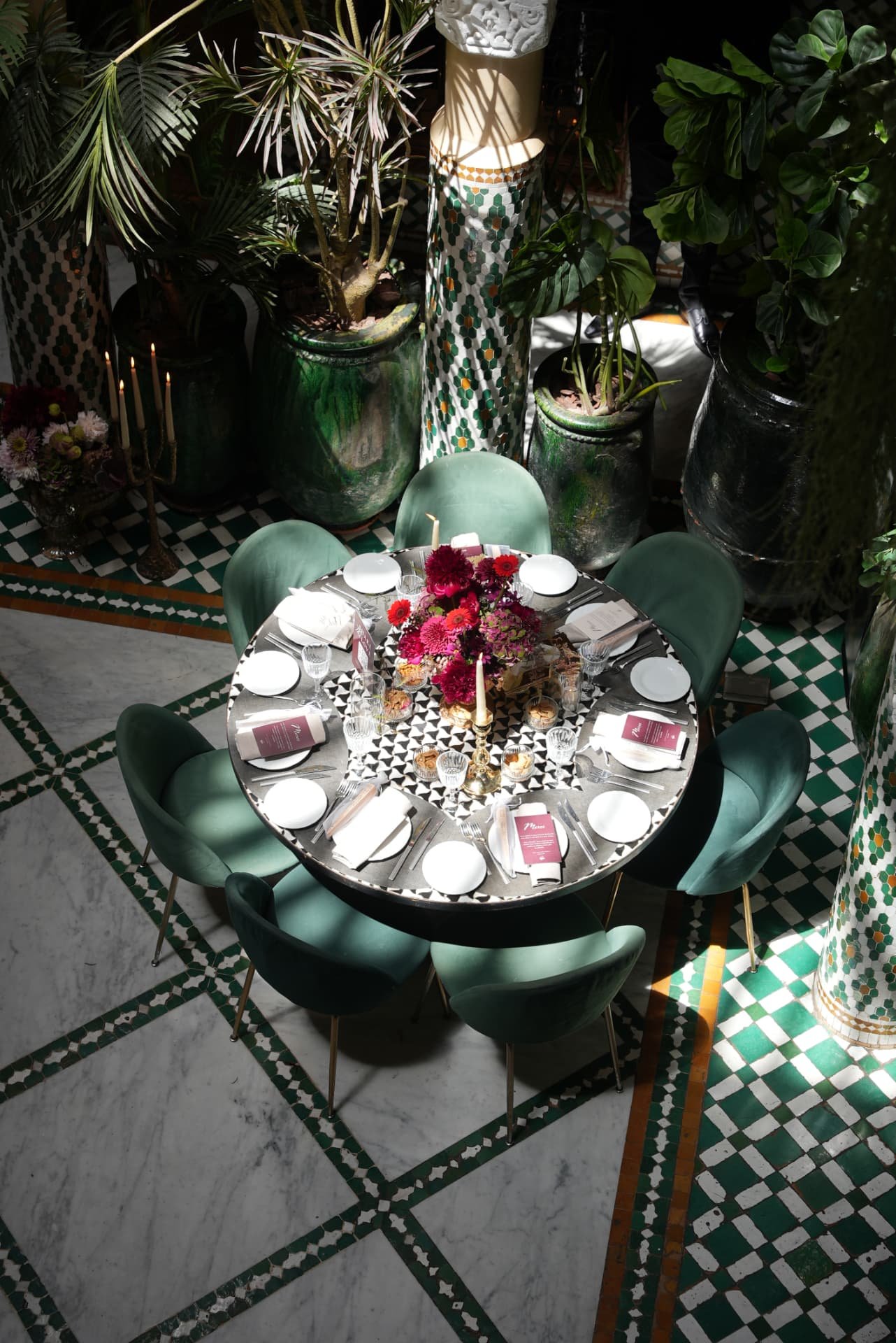 Wedding at Dar Dada Casablanca — gilded welcome mirror, crimson and burgundy floral centerpieces, zellige tables and candlelight, produced by SBAI Events Production