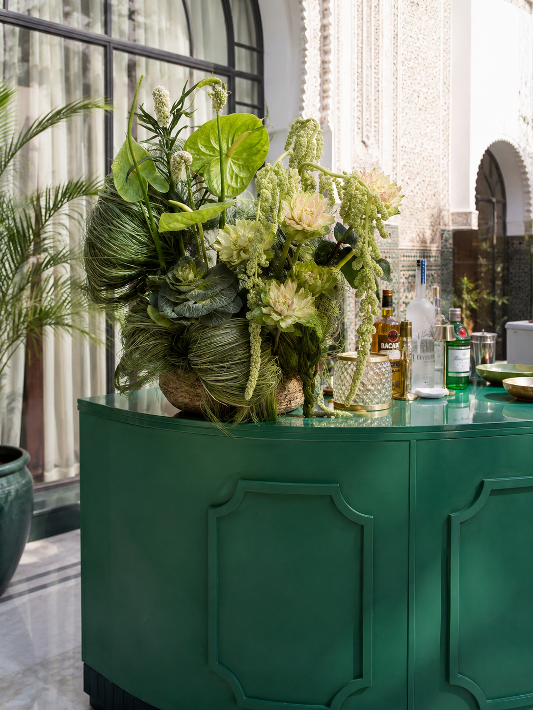 Gala Dinner Vegetal Garden at the patio of the Oberoi Marrakech — purple vanda orchids and anthuriums on white plinths above the emerald reflecting pool, ivory lounges and brass lanterns, produced by SBAI Events Production