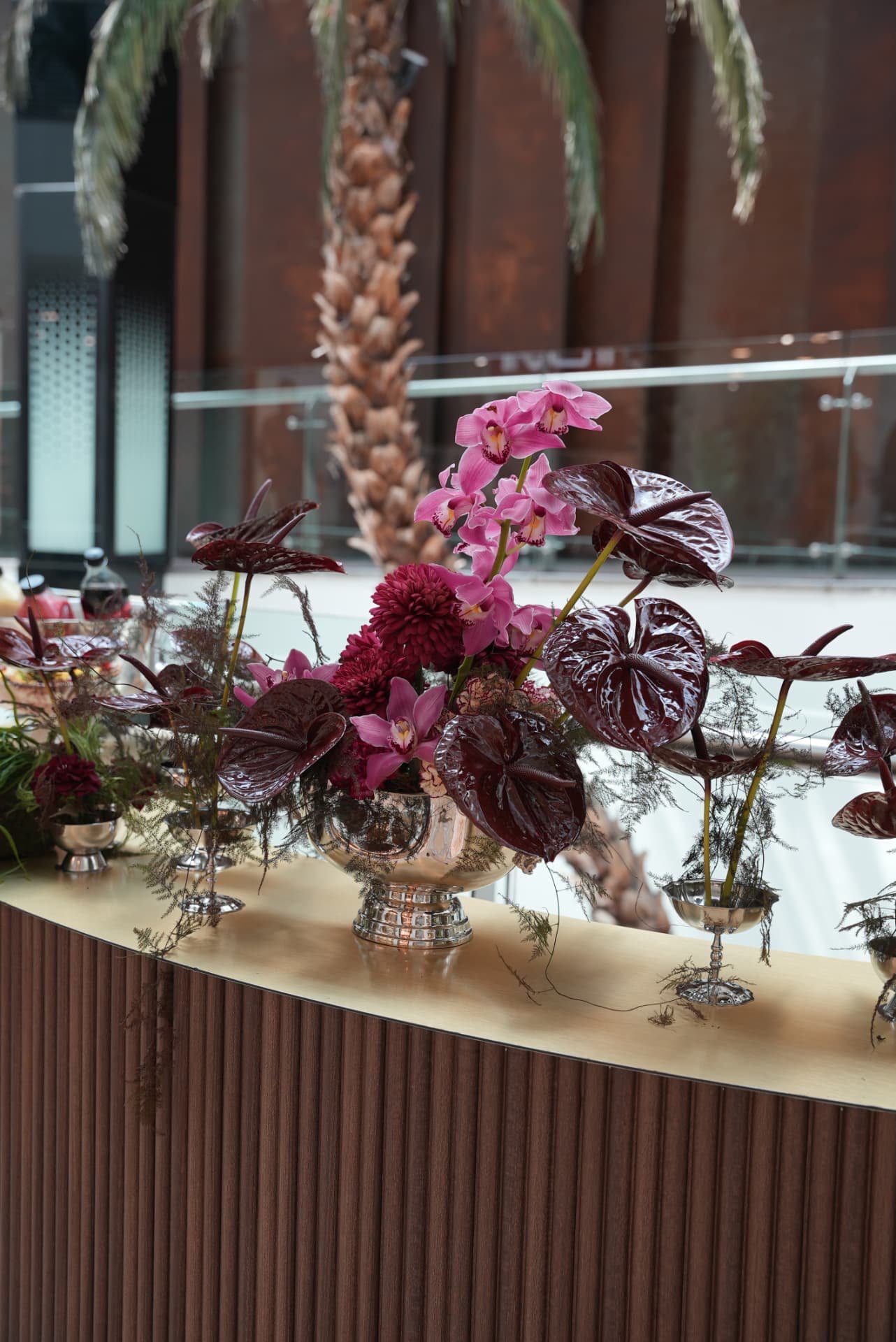 Kara.S boutique opening at Morocco Mall — burgundy anthurium and pink cymbidium installations, silver coupes and brass tables, produced by SBAI Events Production